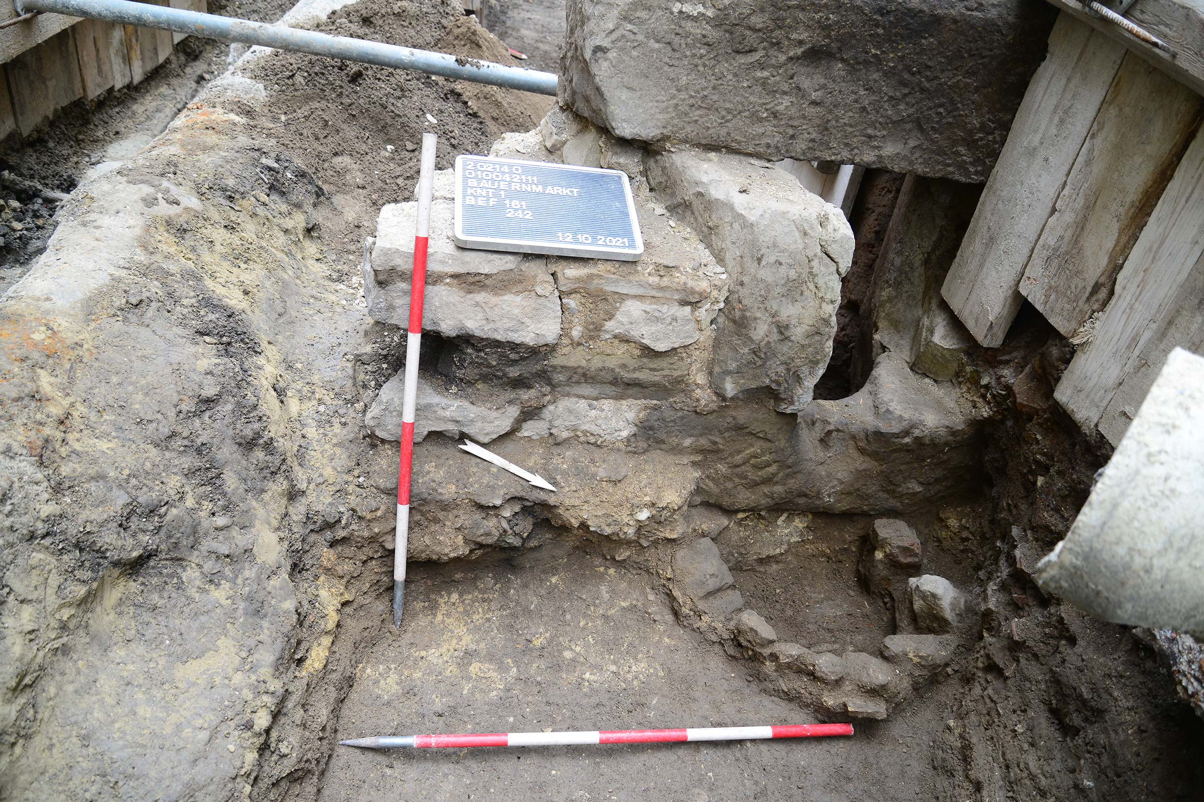 Archäologische Grabungsstelle mit freigelegter Mauer aus Stein