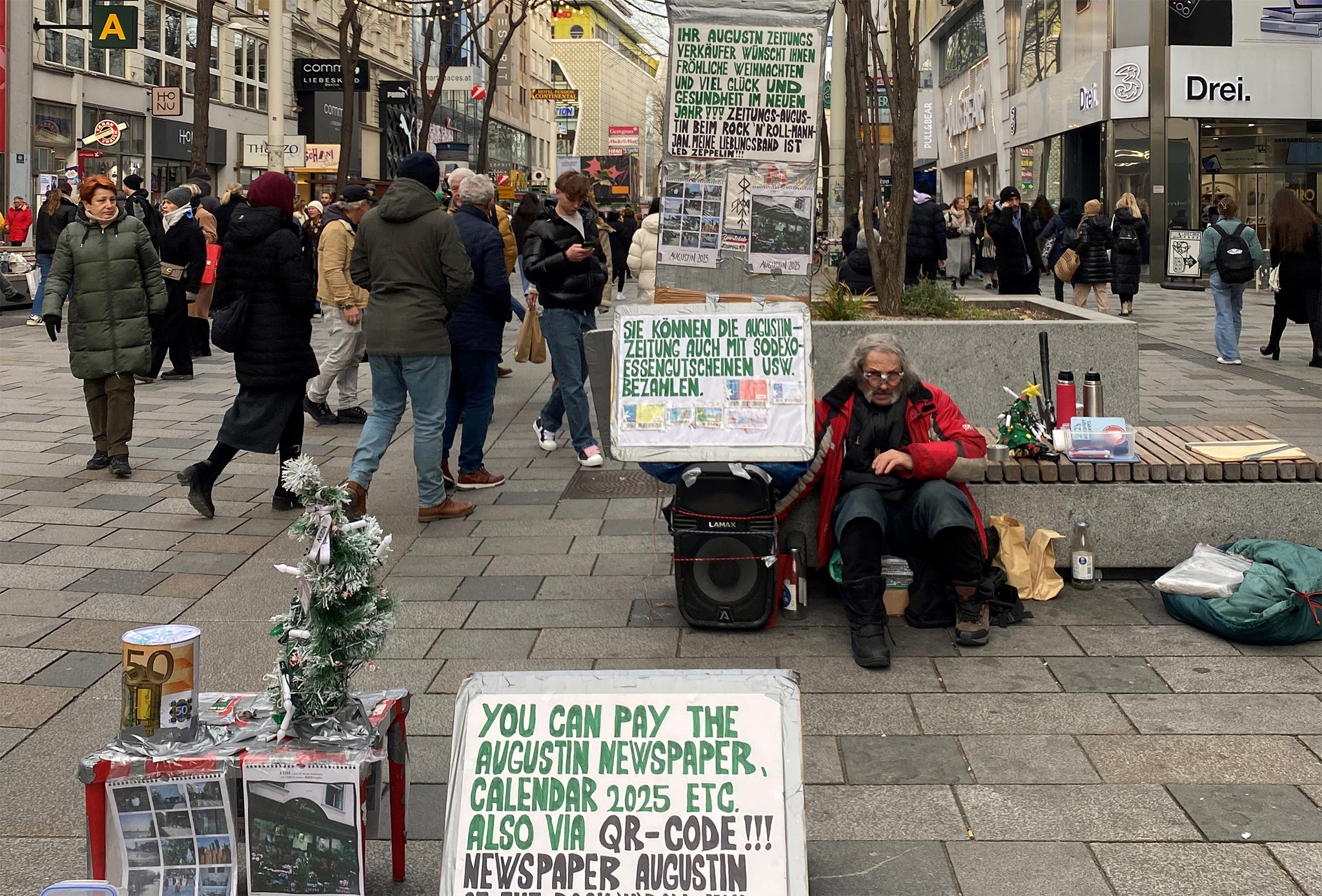 Ein Straßenverkäufer sitzt in einer Einkaufsstraße und bietet 